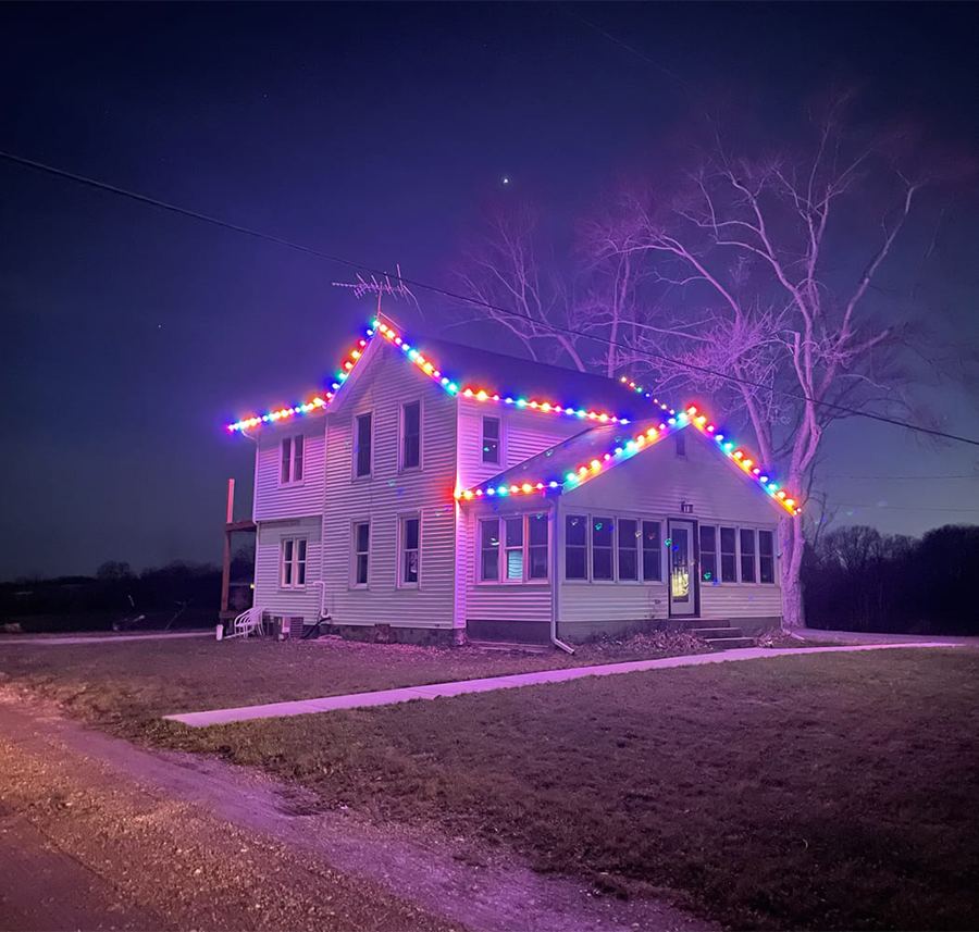 Two-story home with multicolor roofline Christmas lights