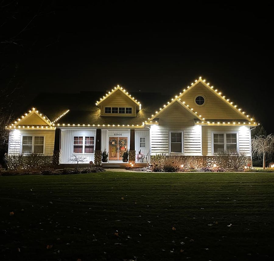 Single-story home with white string lights along the roofline